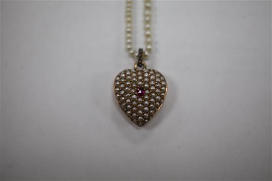 An early 20th century gold, ruby and split pearl set heart shaped pendant locket, pendant inc. bale 1in.